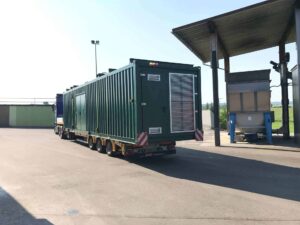 Grüner BHKW-Container auf einem Tieflader