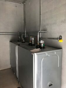 Zwei Öltanks mit Rohrleitungen in einem Technikraum