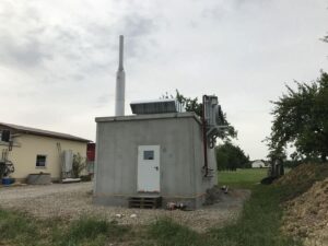 BHKW-Betongebäude mit Schornstein auf einem Hofgelände