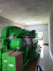 Grüner Jenbacher-Motor in einem hellen, frisch gestrichenen Maschinenraum