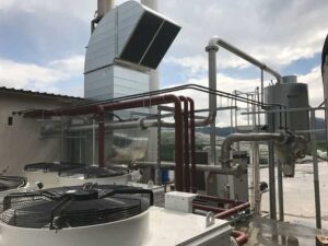 Ventilatoren und Rohrleitungen auf dem Dach eines BHKW-Gebäudes