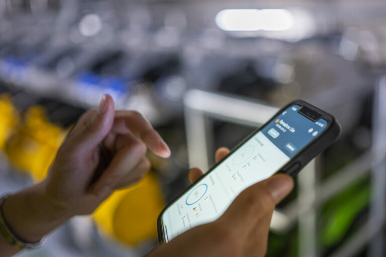 Hand hält Smartphone mit App zur Überwachung von Energieanlagen