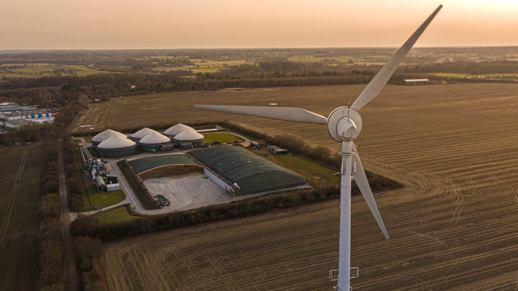 Luftaufnahme einer Biogasanlage mit Windrad