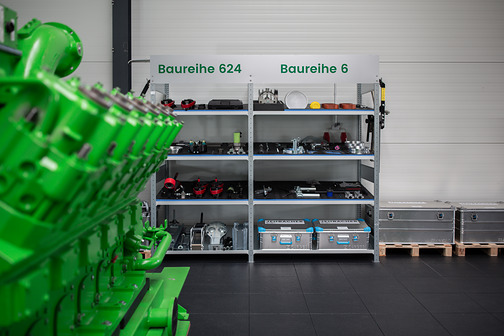 Grüner Motor vor einem Regal mit Werkzeugen und Bauteilen, beschriftet mit Baureihe 624 und Baureihe 6